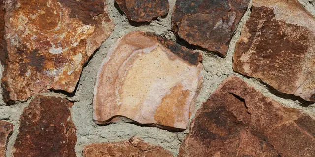 Stones arranged in a structured, textured wall pattern, representing stability in ERP therapy for OCD.