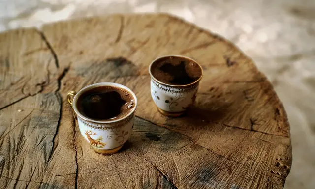 Two warm coffee cups on a wooden table, representing calm connection and ADHD couples therapy in San Francisco.